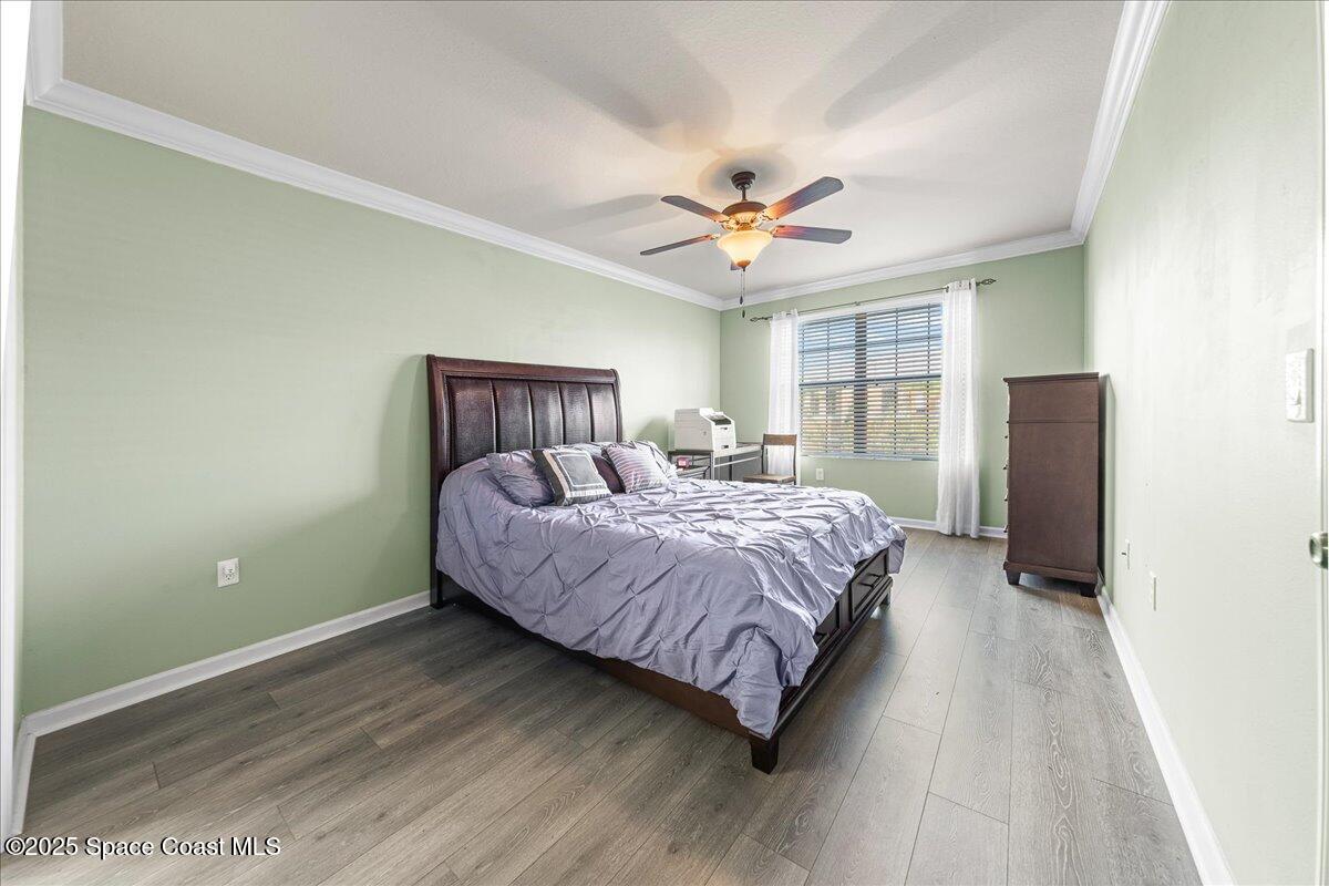 1345 Lara Circle, Unit 102 Rockledge, FL 32955 - Photo 19 of 34 a spacious bedroom with a bed and a chandelier