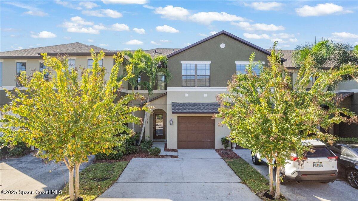 1345 Lara Circle, Unit 102 Rockledge, FL 32955 - Photo 30 of 34 a front view of a house with a yard and garage