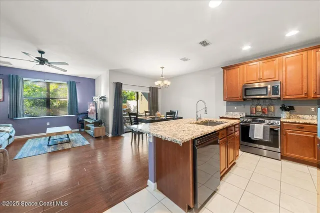 a kitchen with stainless steel appliances granite countertop a sink and a refrigerator