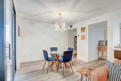 a view of a dining room with furniture and chandelier