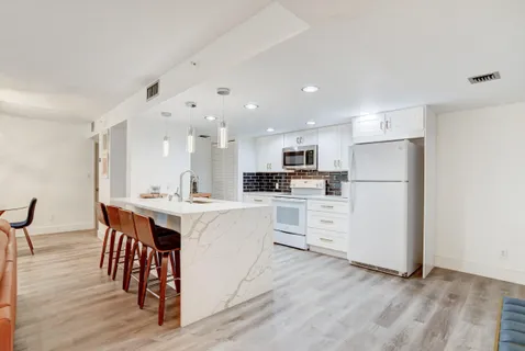 a kitchen with white cabinets and white appliances