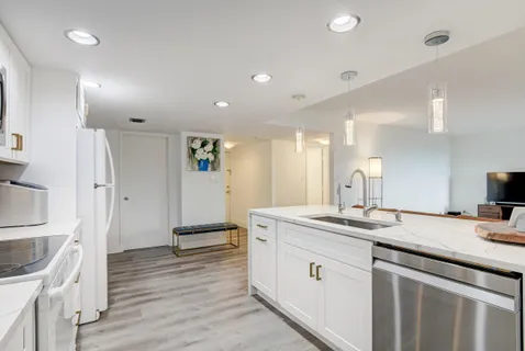 a spacious bathroom with a granite countertop sink a mirror a vanity and a shower