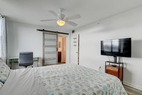a bedroom with a bed and a flat screen tv