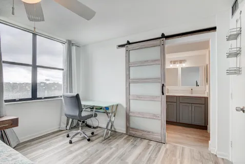 a view of a workspace with furniture and a window