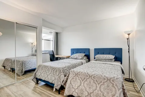 a bedroom with two beds and a lamp