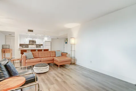 a living room with furniture and a view of kitchen