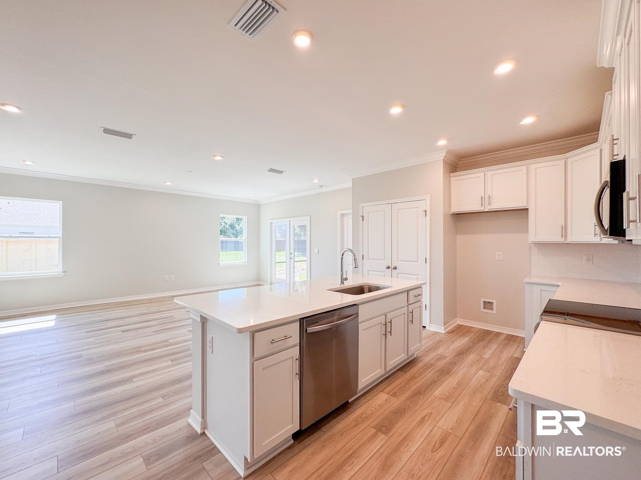 23939 Dominus Drive Daphne, AL 36526 - Photo 2 of 9 Kitchen featuring white cabinetry, recessed lighting, light wood-style floors, stainless steel appliances, and an island with sink