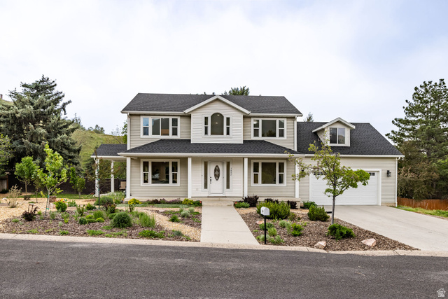1552 Sumac Drive Logan, UT 84321 - Photo 56 of 72 Two-story residence featuring light-colored siding, dark shingle roofing, and a prominent front entry with a white door