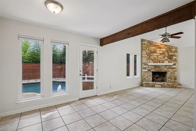 a view of an empty room with a fireplace and a window