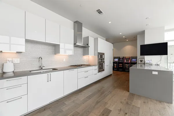a kitchen with stainless steel appliances granite countertop a stove a sink and white cabinets