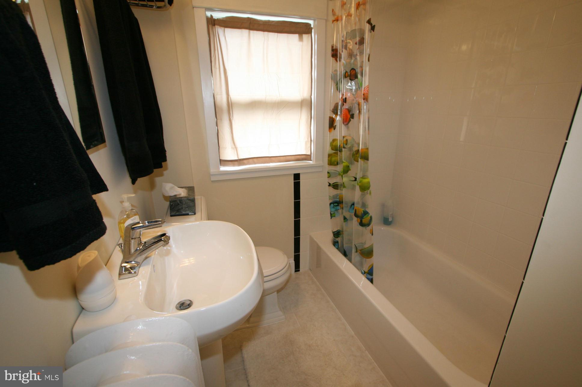 500 Cleveland Road Linthicum Heights, MD 21090 - Photo 18 of 26 a bathroom with a tub a sink and a window