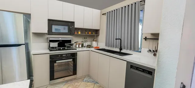 a kitchen with granite countertop a sink stove and refrigerator