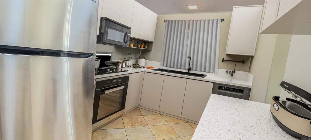 1469 Sundance Way Oceanside, CA 92057 - Photo 4 of 27 a kitchen with a refrigerator stove and a sink