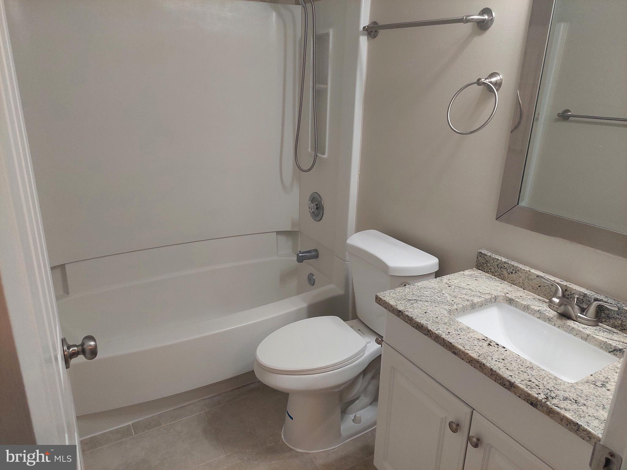 10149 Shelldrake Circle Damascus, MD 20872 - Photo 54 of 73 a bathroom with a granite countertop toilet a sink and a bathtub