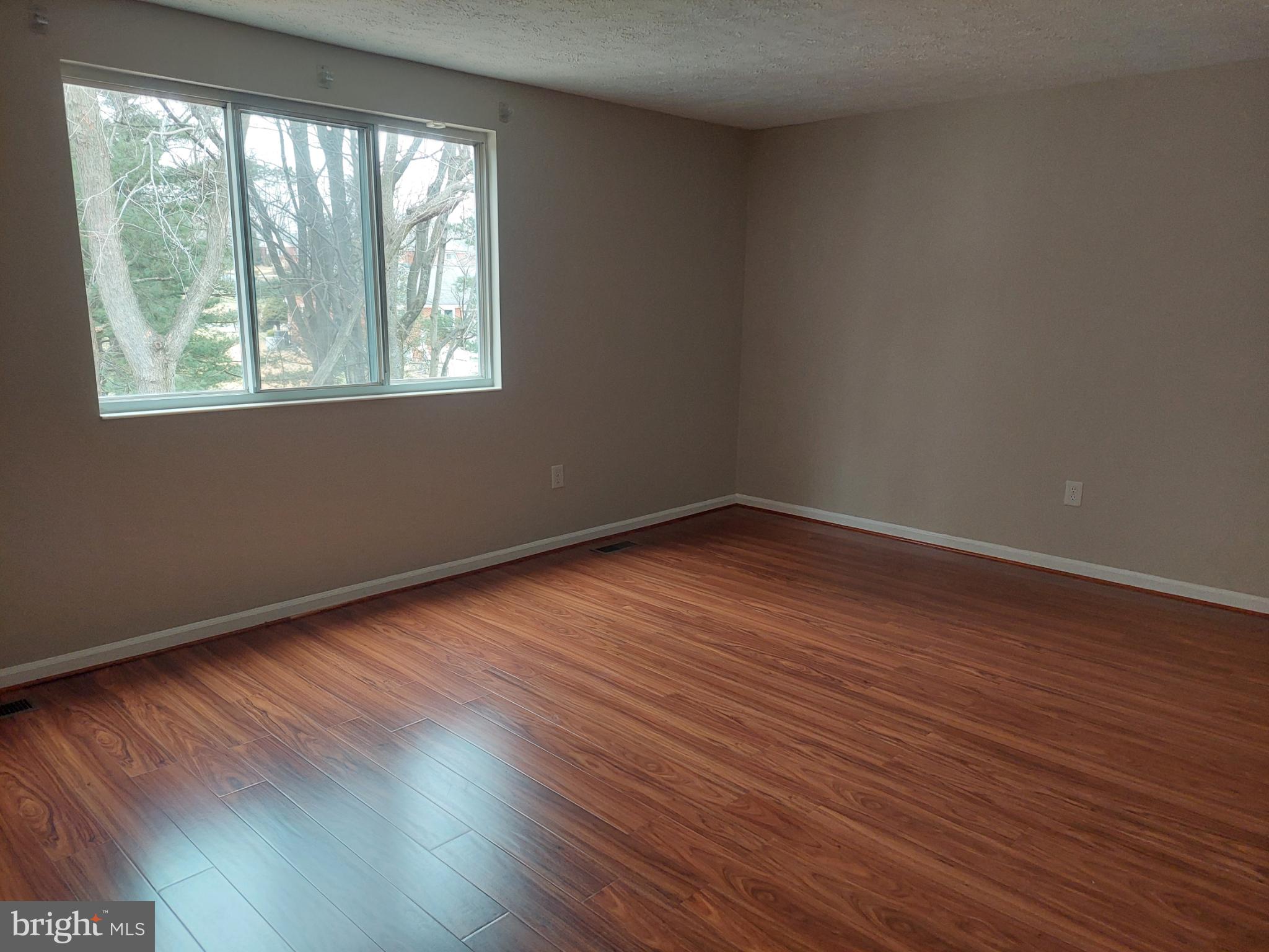 10149 Shelldrake Circle Damascus, MD 20872 - Photo 60 of 73 a view of an empty room with wooden floor and a window
