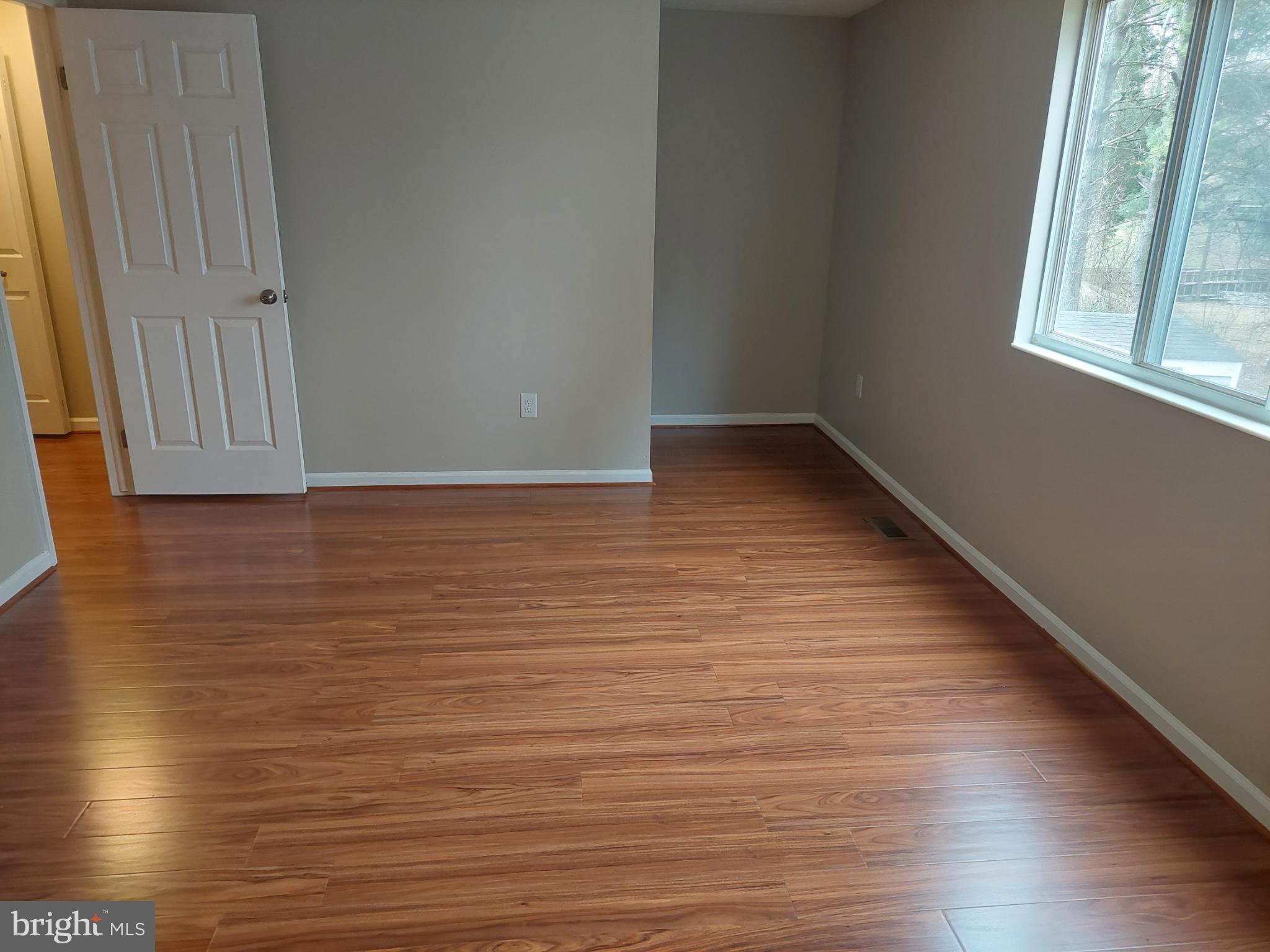 10149 Shelldrake Circle Damascus, MD 20872 - Photo 65 of 73 a view of an empty room with wooden floor and a window