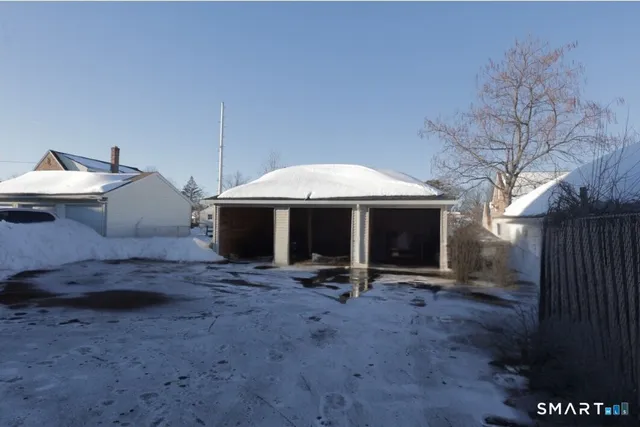 a view of a patio with a table and chairs under an umbrella with wooden fence