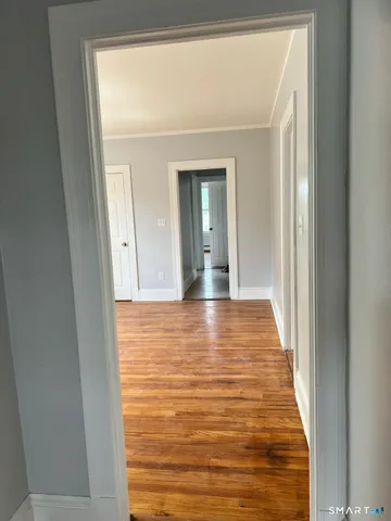 a view of a room with wooden floor and a window