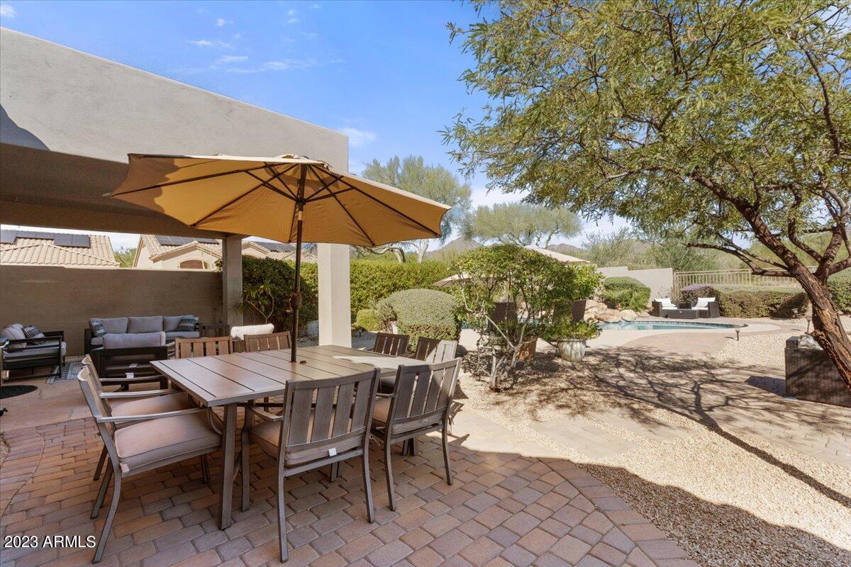 14257 North 106th Place Scottsdale, AZ 85255 - Photo 47 of 58 a view of a patio with a table and chairs under an umbrella