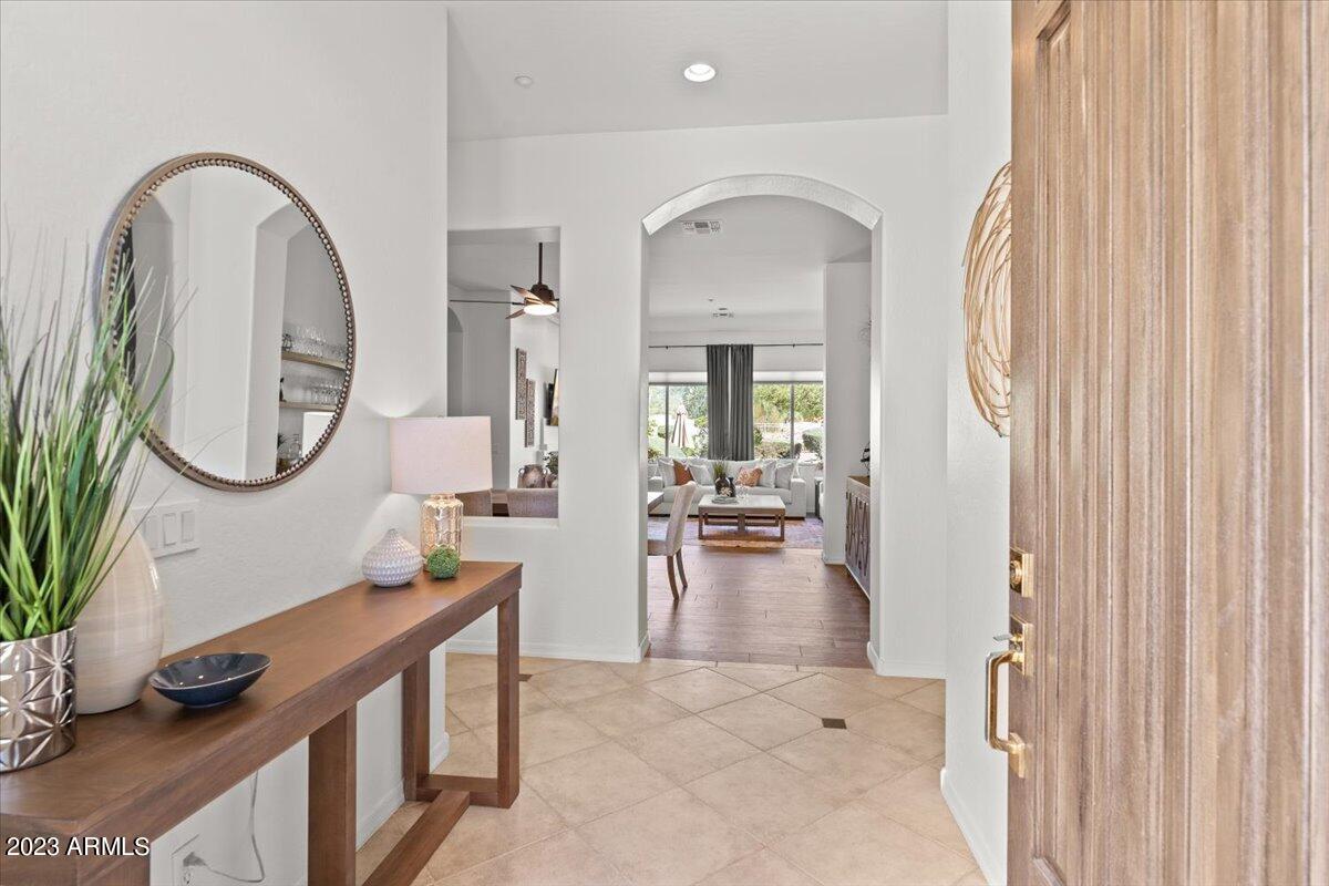 14257 North 106th Place Scottsdale, AZ 85255 - Photo 7 of 58 a living room with furniture a mirror and a clock