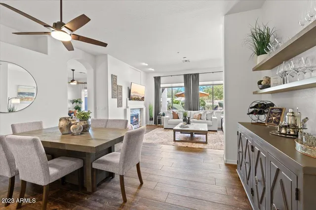 a dining room with wooden floor a glass table and chairs