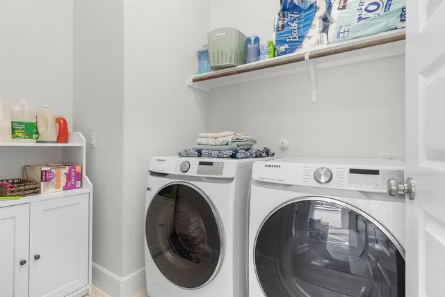 a kitchen with a stove a sink and white cabinets