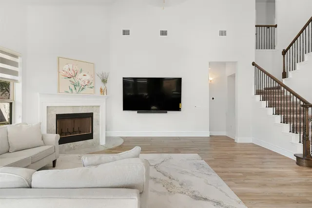 a living room with furniture a flat screen tv and a fireplace