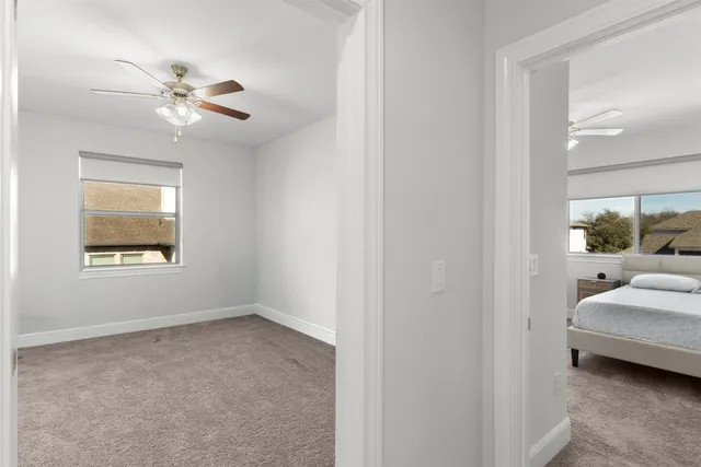 an empty room with a window and a fan