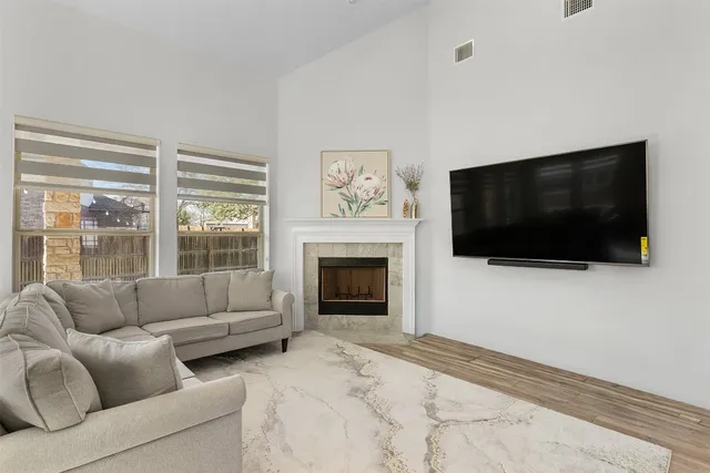 a living room with furniture a flat screen tv and a fireplace