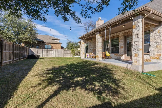 a view of a house with a big yard plants and large tree