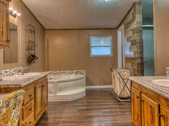 6341 Farm Private Road Levelland, TX 79336 - Photo 18 of 46 a spacious bathroom with a granite countertop sink a toilet a mirror and shower