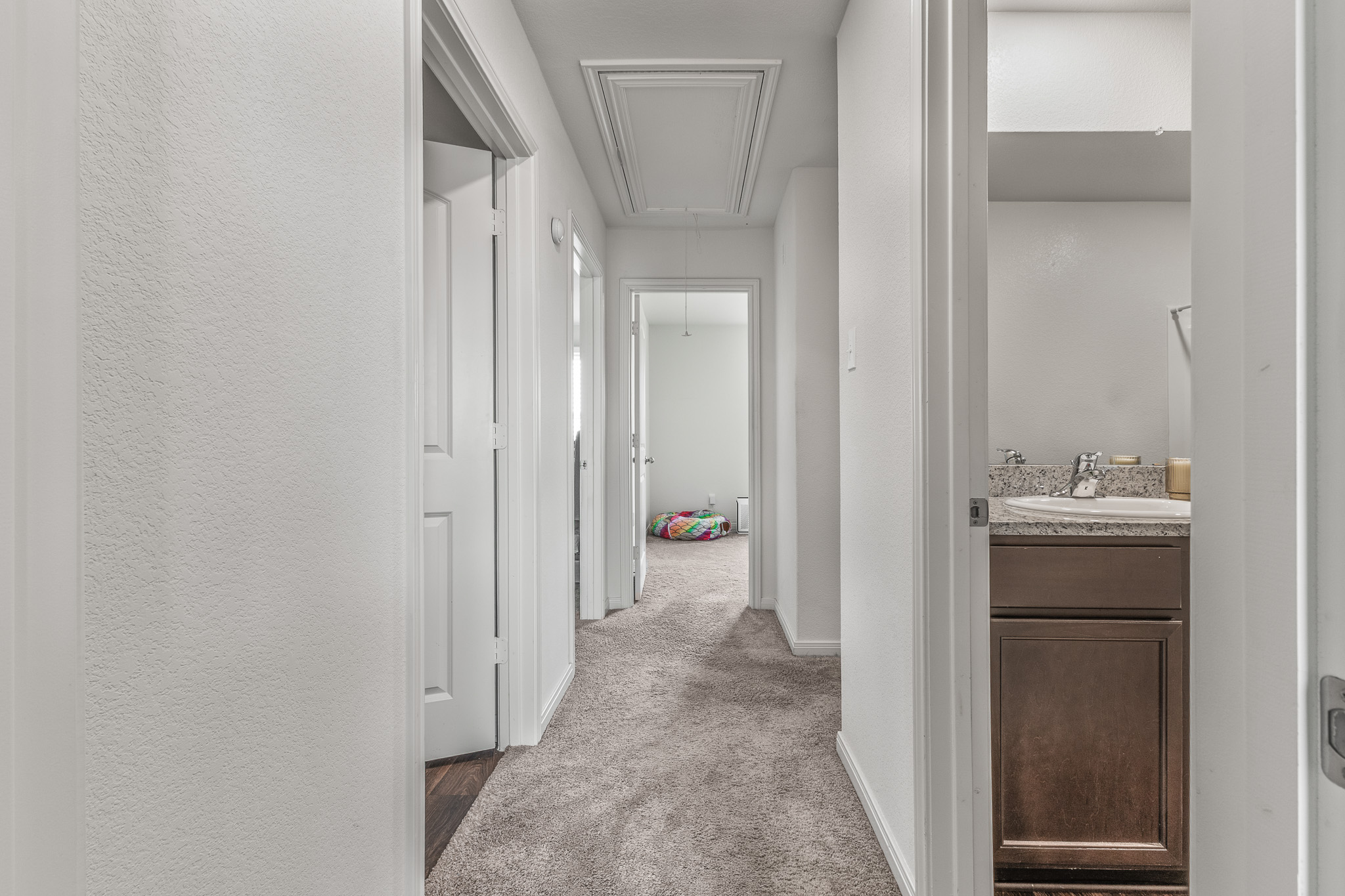 304 Hyacinth Way, Unit #7K Jarrell, TX 76537 - Photo 19 of 26 A well-lit interior hallway offers plush carpeting and access to multiple rooms.