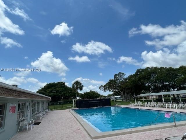7305 Northwest 95th Way Tamarac, FL 33321 - Photo 2 of 24 a view of a swimming pool with a table and chairs