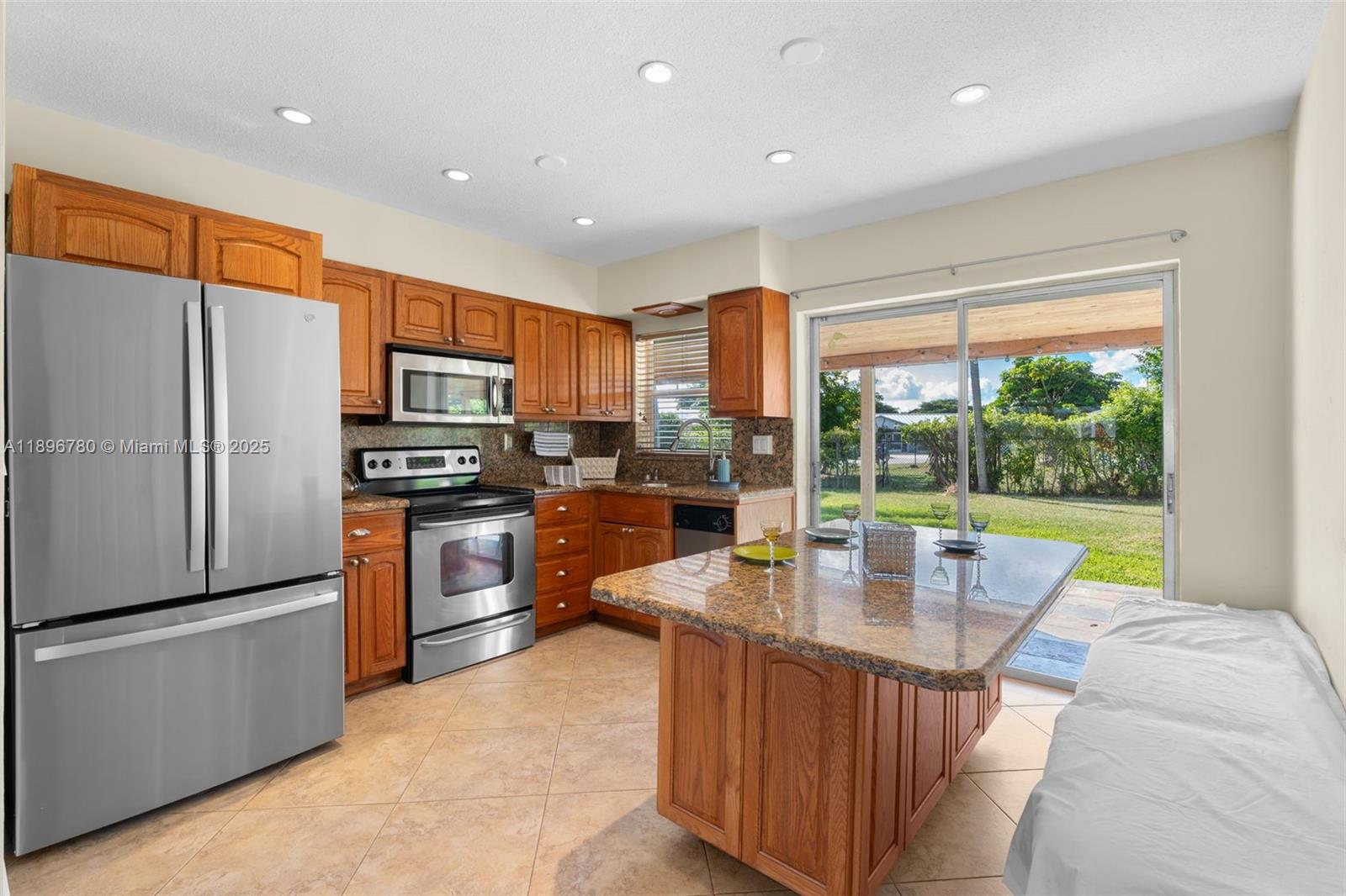 7305 Northwest 95th Way Tamarac, FL 33321 - Photo 5 of 24 a open kitchen with kitchen island a large window cabinets a refrigerator and a sink
