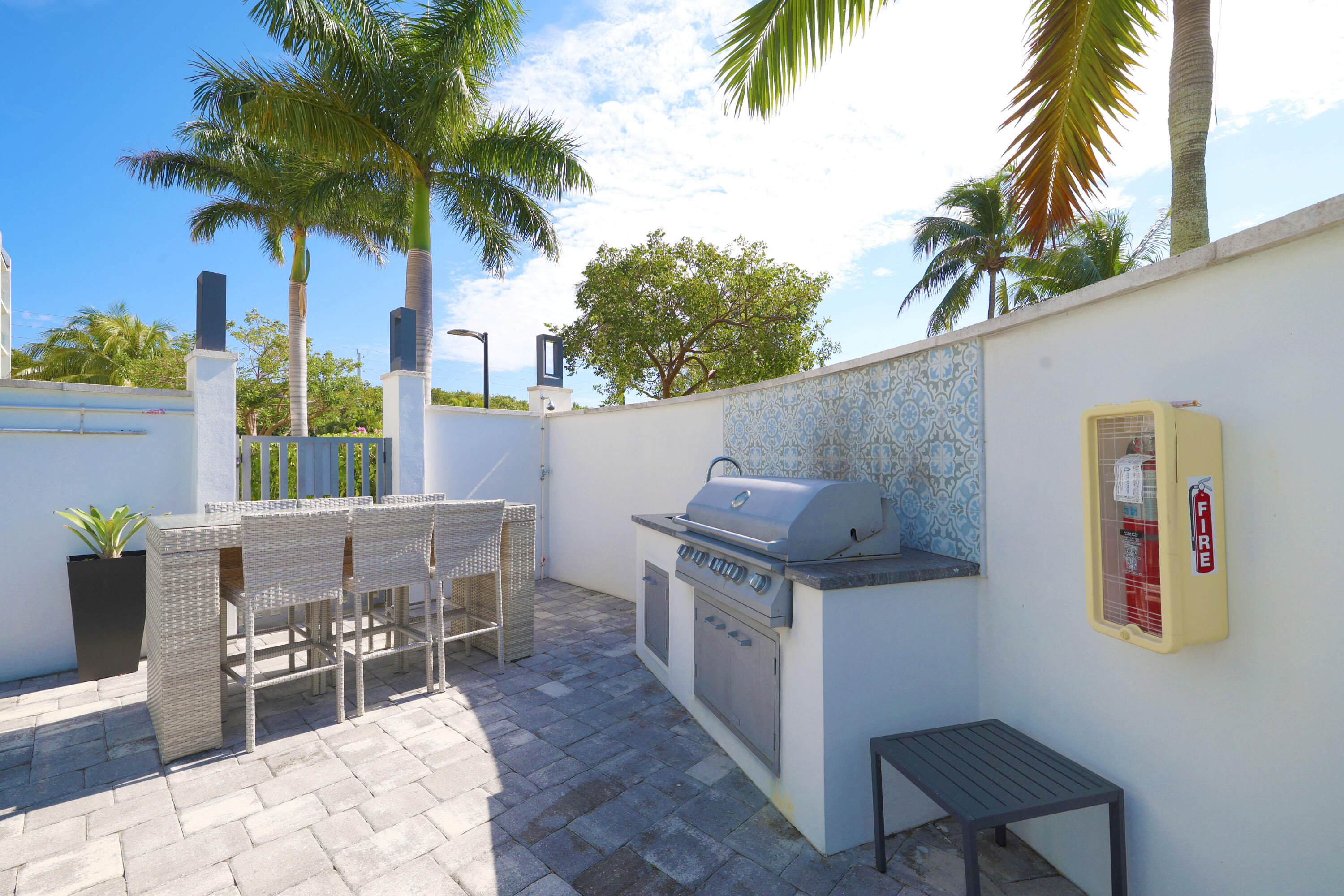 601 North Ocean Boulevard Boca Raton, FL 33432 - Photo 27 of 36 a view of a patio with table and chairs potted plants and palm trees