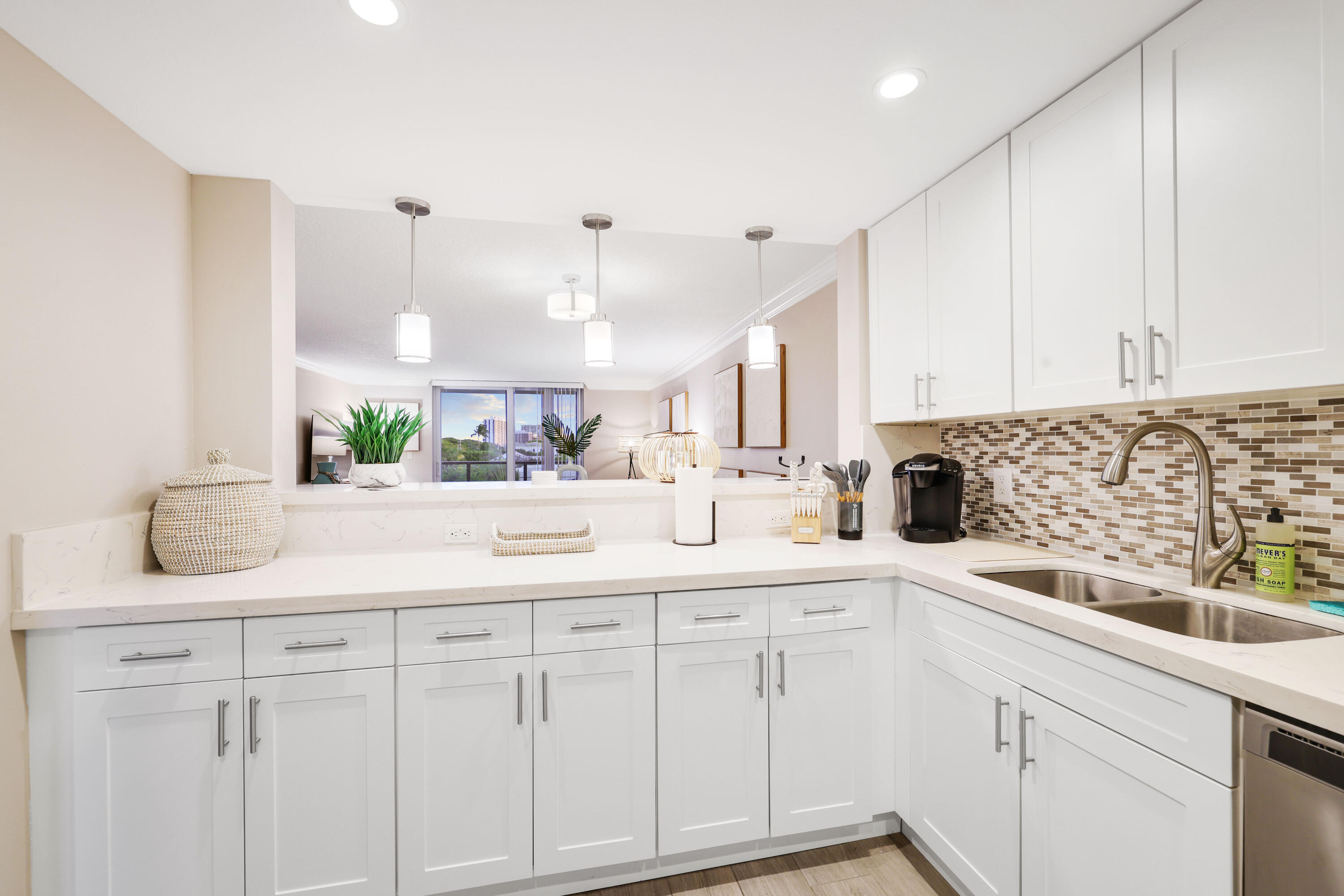 601 North Ocean Boulevard Boca Raton, FL 33432 - Photo 6 of 36 a kitchen with white cabinets and sink