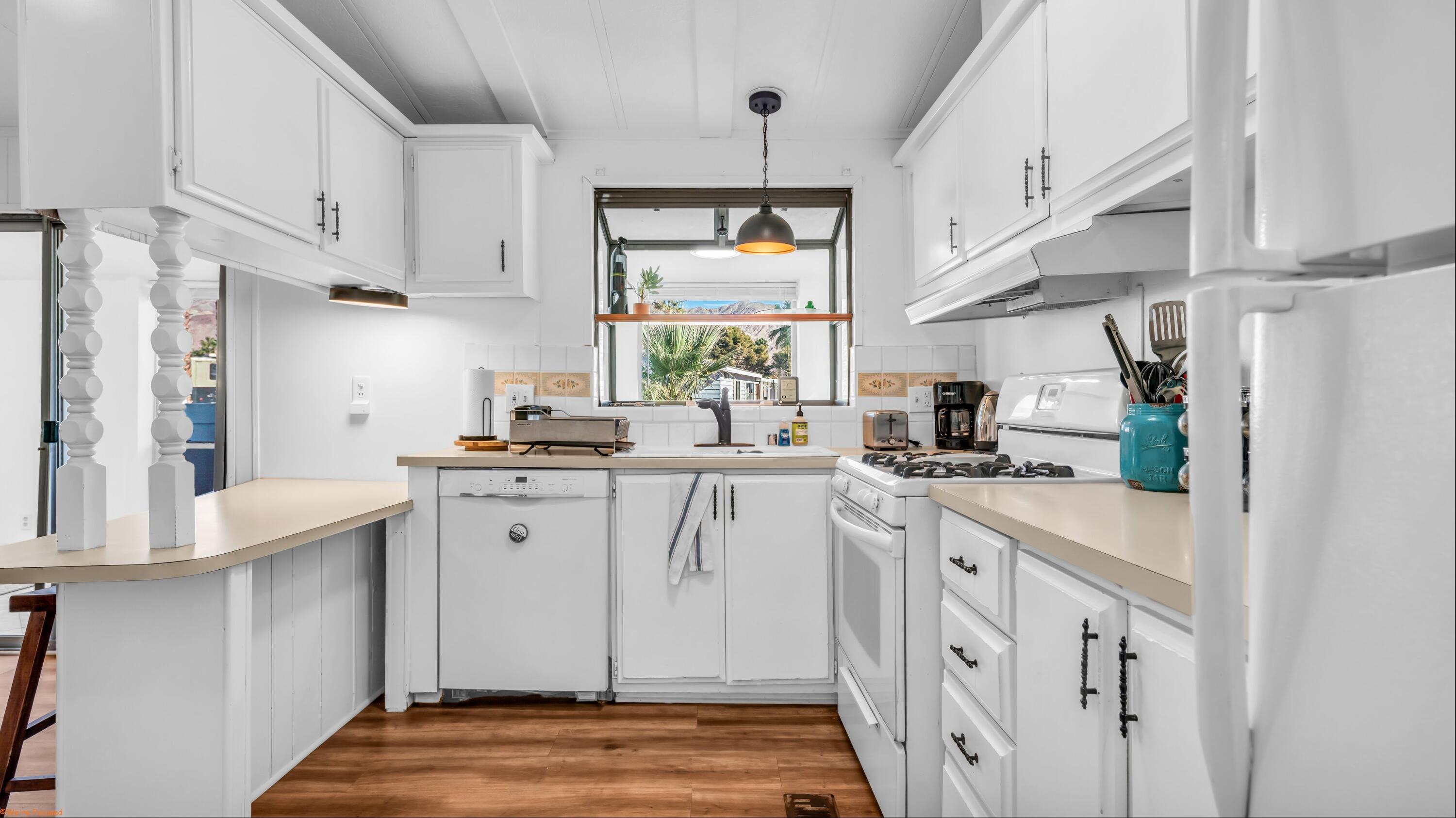 74711 Dillon Road, Unit 392 Desert Hot Springs, CA 92241 - Photo 10 of 46 a kitchen with white cabinets and window