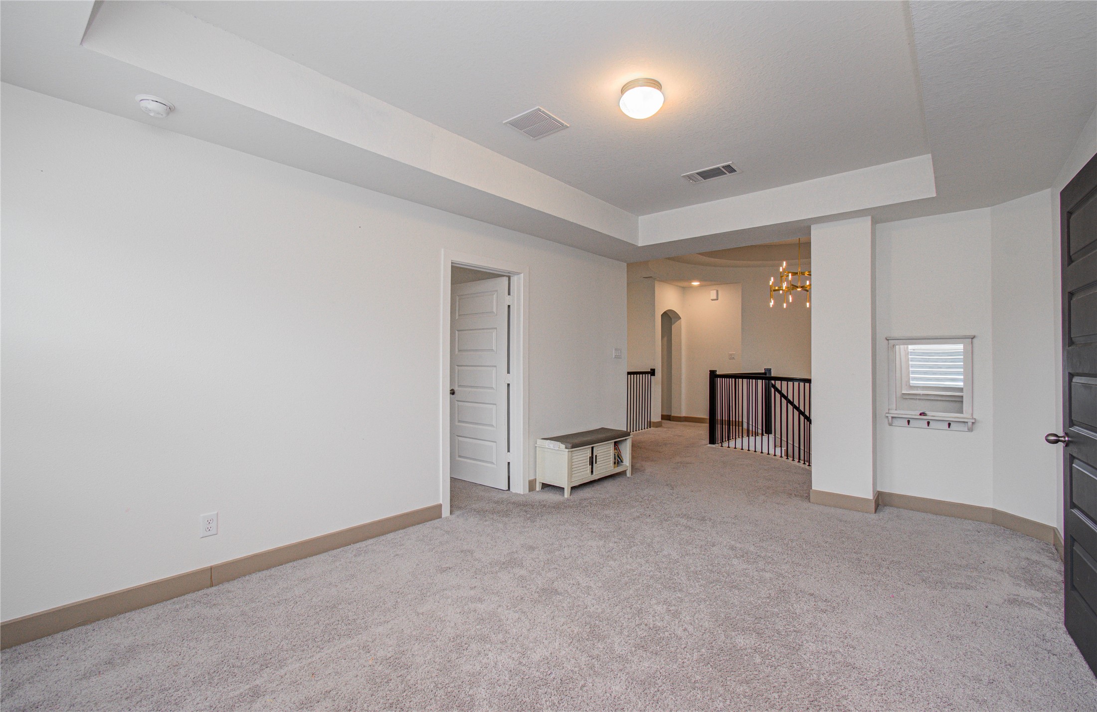 4211 Limestone Terrace Manvel, TX 77578 - Photo 21 of 33 This spacious, carpeted room features soft neutral walls, recessed lighting, and a small window for natural light. It includes a doorway leading to another area and a railing along the stairs, adding an open, airy feel. Perfect for a cozy living space or home office.