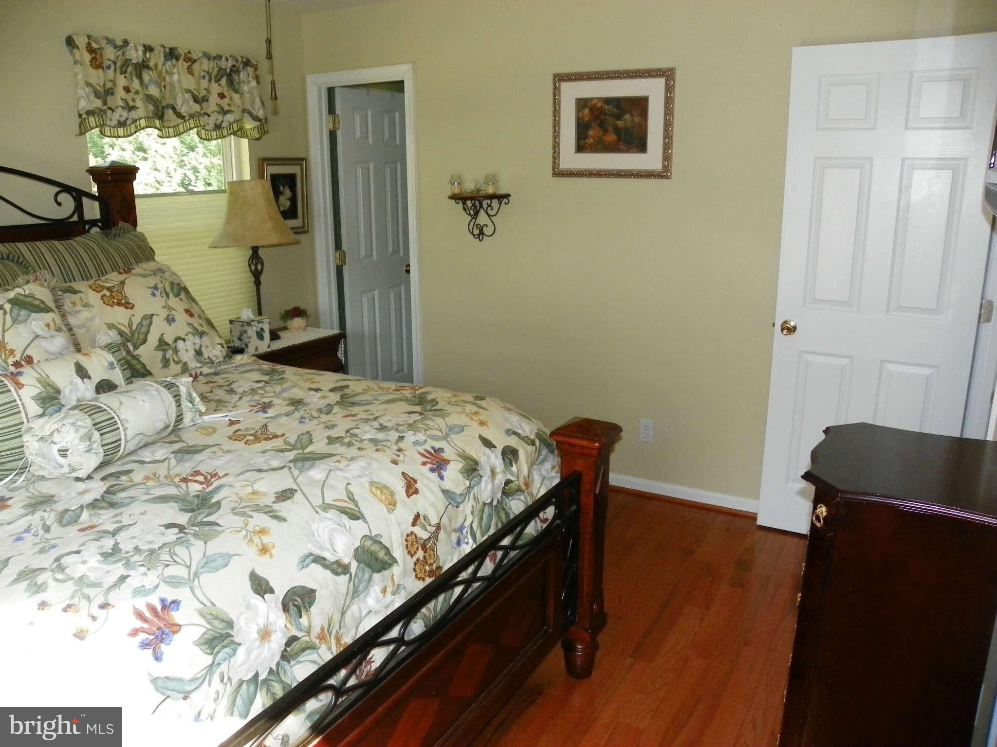 1130 Calvert Beach Road St. Leonard, MD 20685 - Photo 12 of 21 a bedroom with a bed and wooden floor