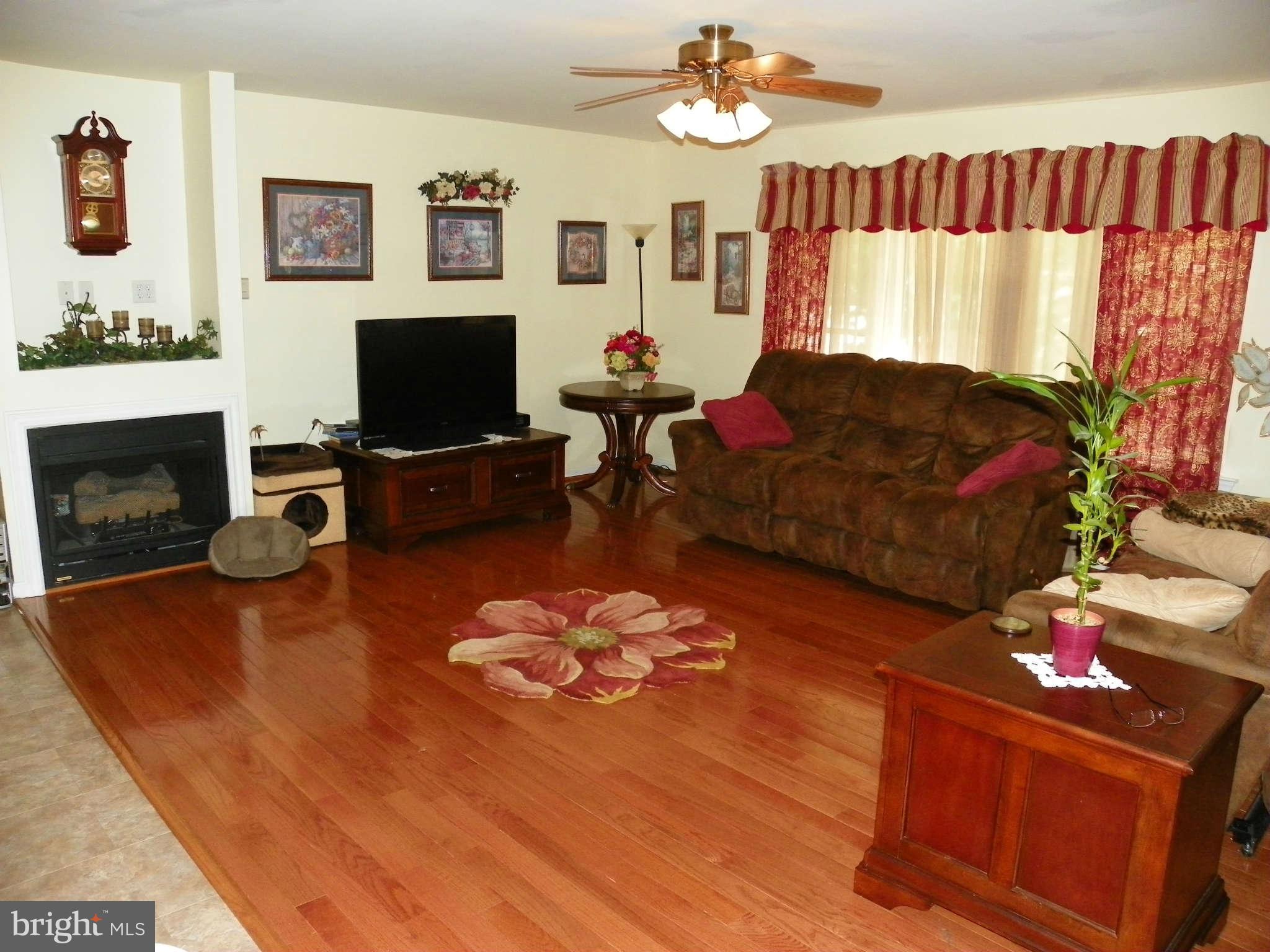 1130 Calvert Beach Road St. Leonard, MD 20685 - Photo 10 of 21 a living room with furniture a flat screen tv and a fireplace