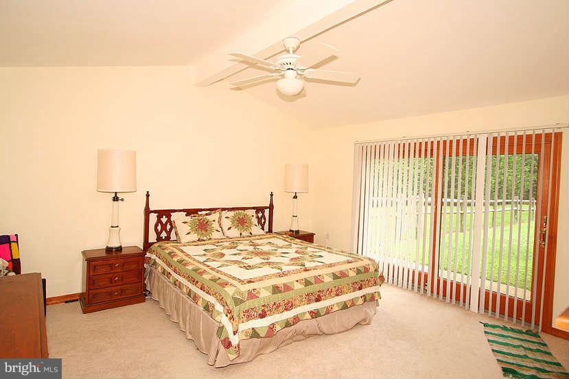 605 Old Point Road Chester, MD 21619 - Photo 26 of 30 a bedroom with a large bed and a chandelier