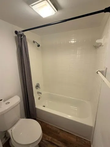 a white toilet and tub sitting next to a bathroom sink