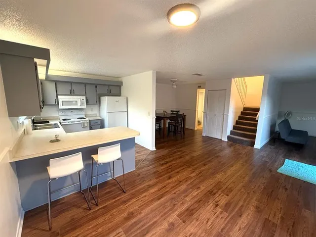 a large kitchen with a wooden floor and outdoor view