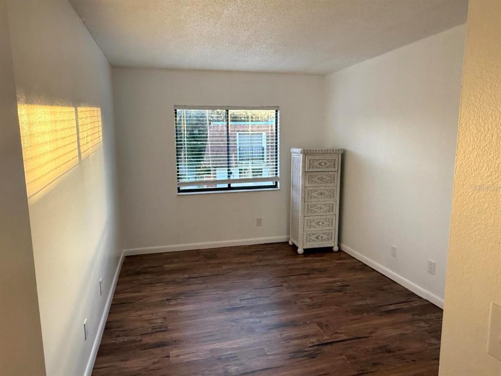 1406 Park Shore Circle, Unit 3 Fort Myers, FL 33901 - Photo 21 of 25 an empty room with wooden floor and windows
