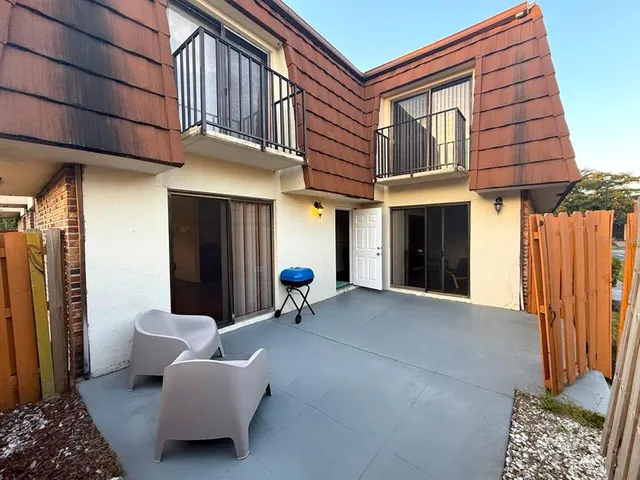 a building outdoor space with patio furniture and potted plants