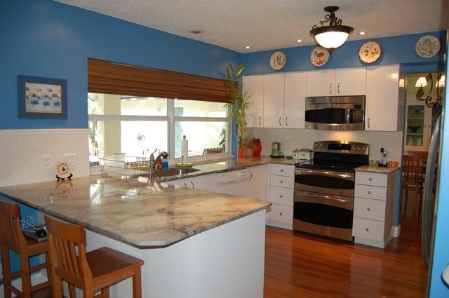 2899 Northwest 24th Court Boca Raton, FL 33431 - Photo 7 of 31 a kitchen with granite countertop a stove and a wooden floor