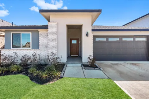a front view of a house with a yard and plants