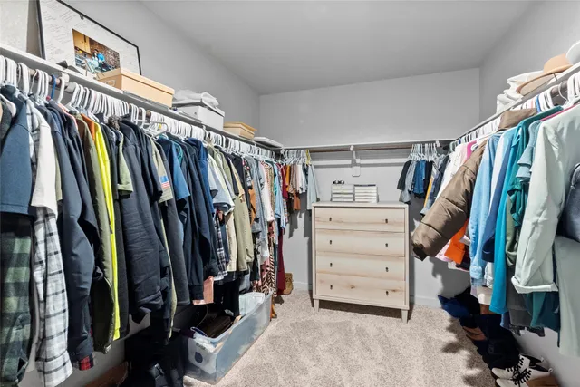 a view of walk in closet with clothes