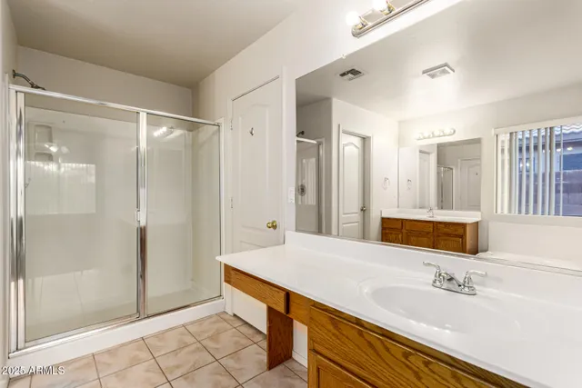 a spacious bathroom with a shower sink and mirror