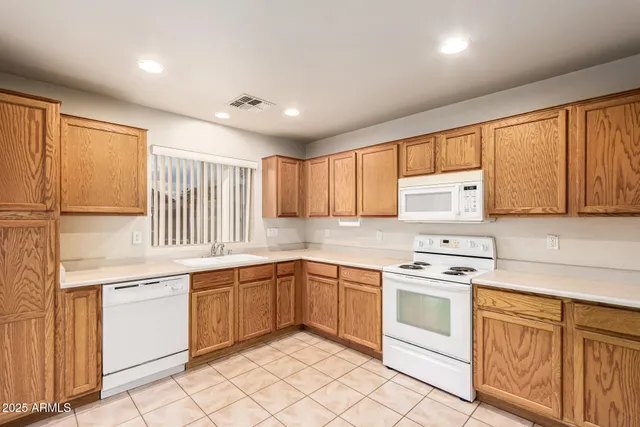 a kitchen with white cabinets appliances and a window